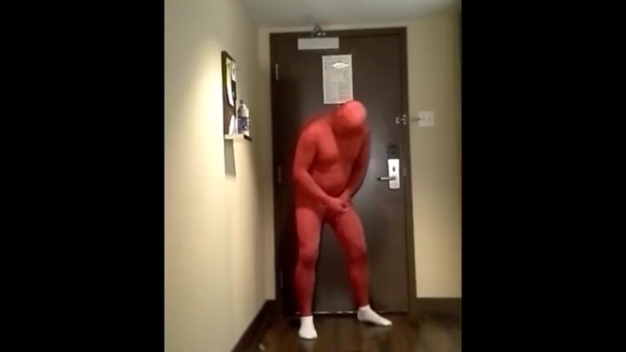 red morphsuit jerking off at hotel room door