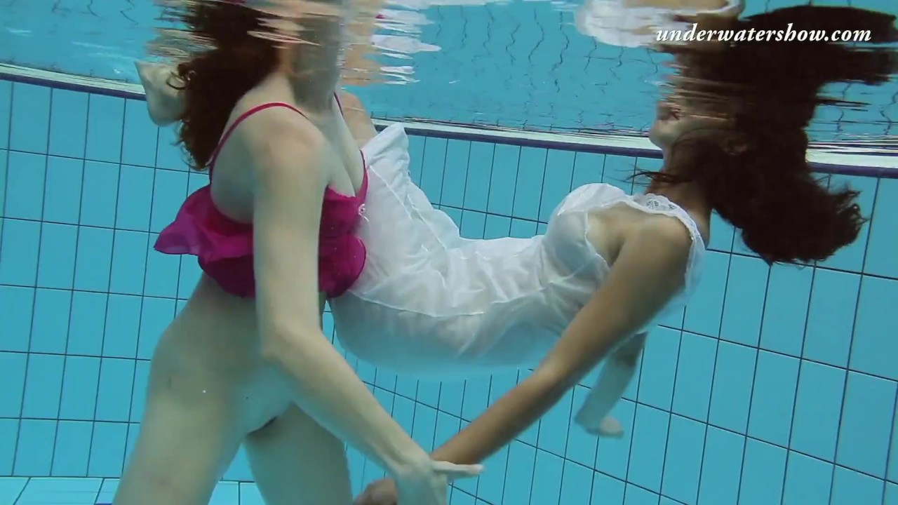 Two girls swim naked underwater