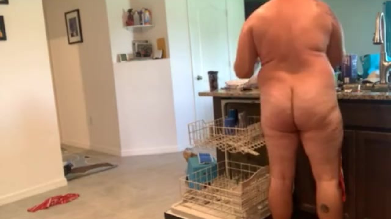 Dad bod naked man doing dishes
